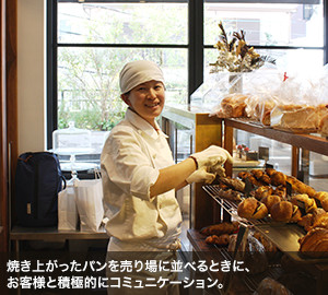 焼き上がったパンを売り場に並べるときに、お客様と積極的にコミュニケーション。
