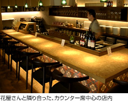 花屋さんと隣り合った、カウンター席中心の店内